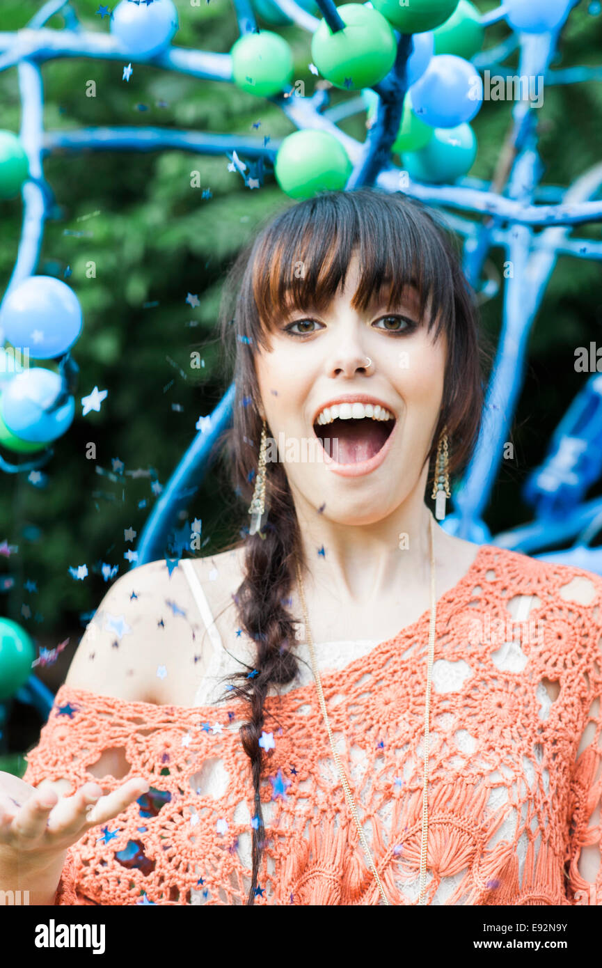 Smiling Young Woman with Star Confetti in Air Stock Photo