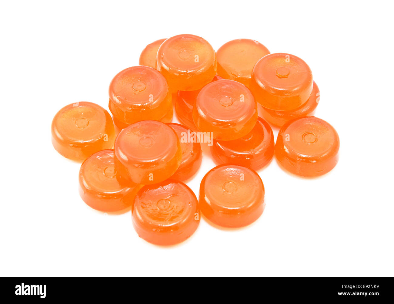 Pile of orange boiled sweets, or hard candies, isolated on a white background Stock Photo
