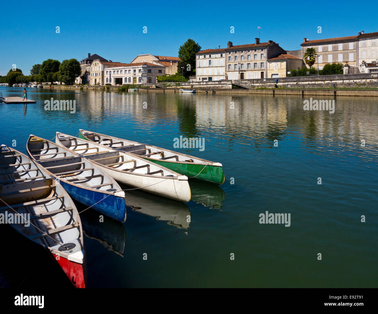Rowing boats moored on the River Charente flowing through Jarnac in the Charente Region of south west France Stock Photo