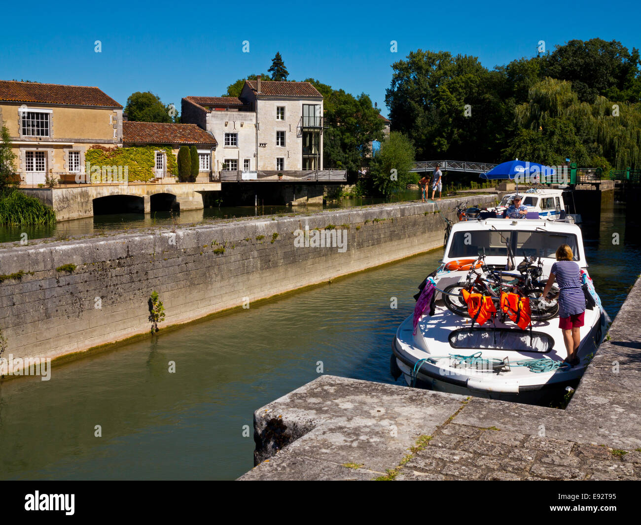 Holiday boat at a lock on the River Charente flowing through Jarnac in the Charente Region of south west France Stock Photo