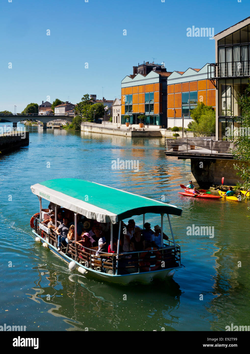 River boat carrying tourists on the River Charente flowing through Jarnac in the Charente Region of south west France Stock Photo
