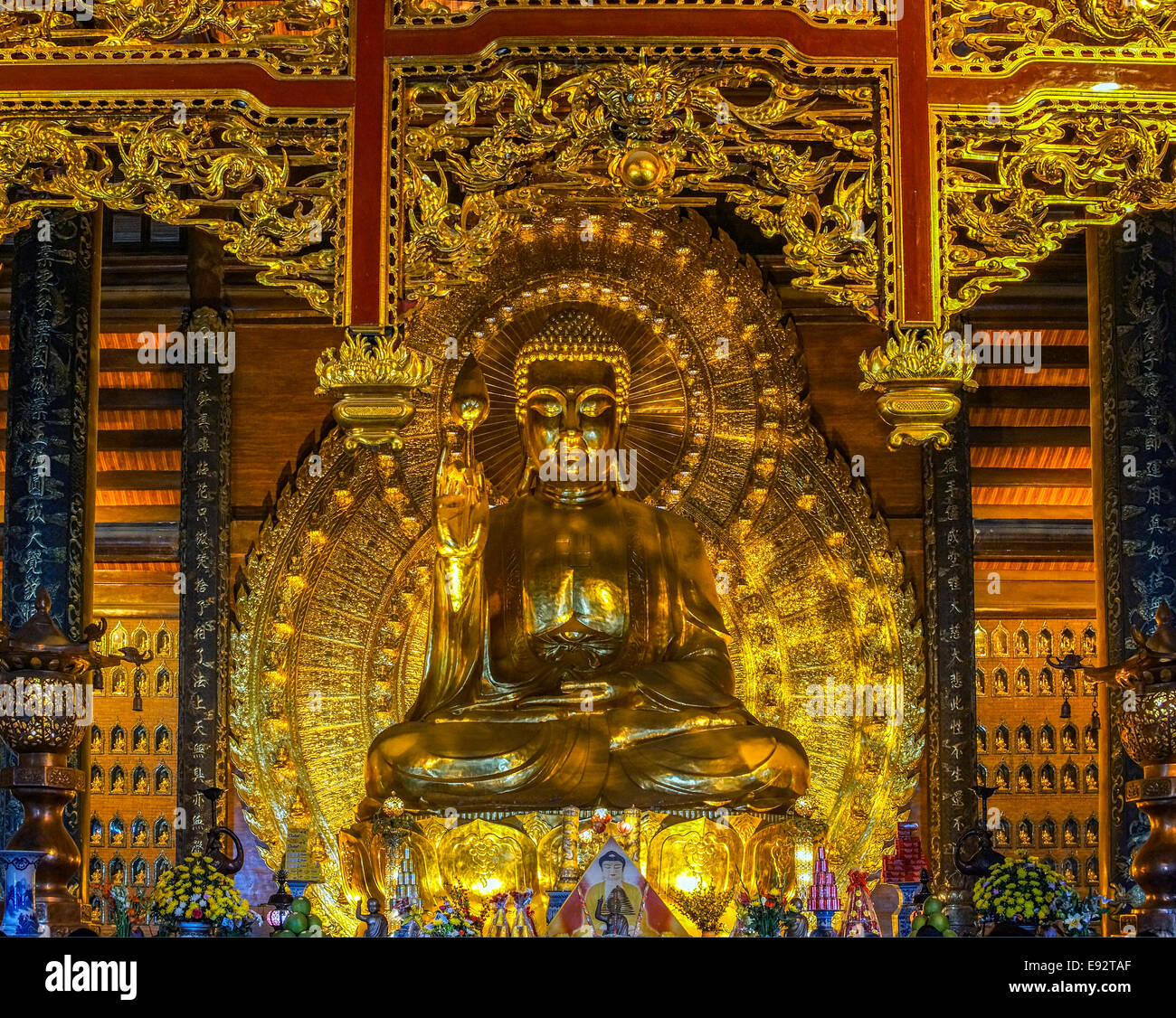 Shiny golden yellow colors on Buddha statue dominate and blind the visitor. Stock Photo