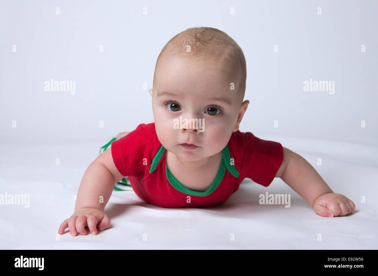 9 month old baby boy holding head up and looking serious, wearing Christmas colors Stock Photo