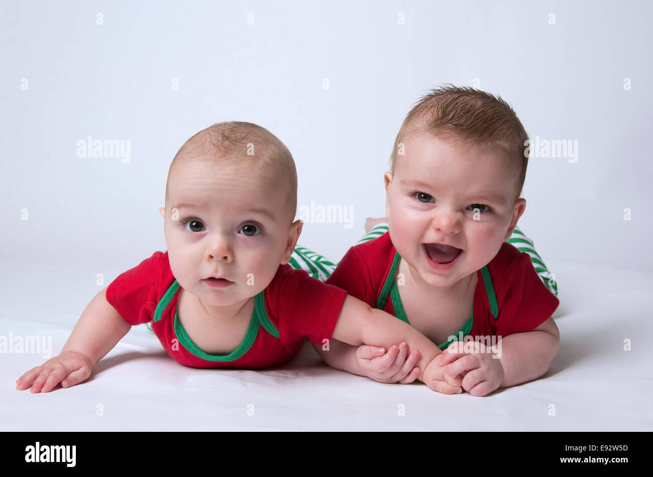 Very happy 9 month old fraternal twins boys wearing Christmas colours