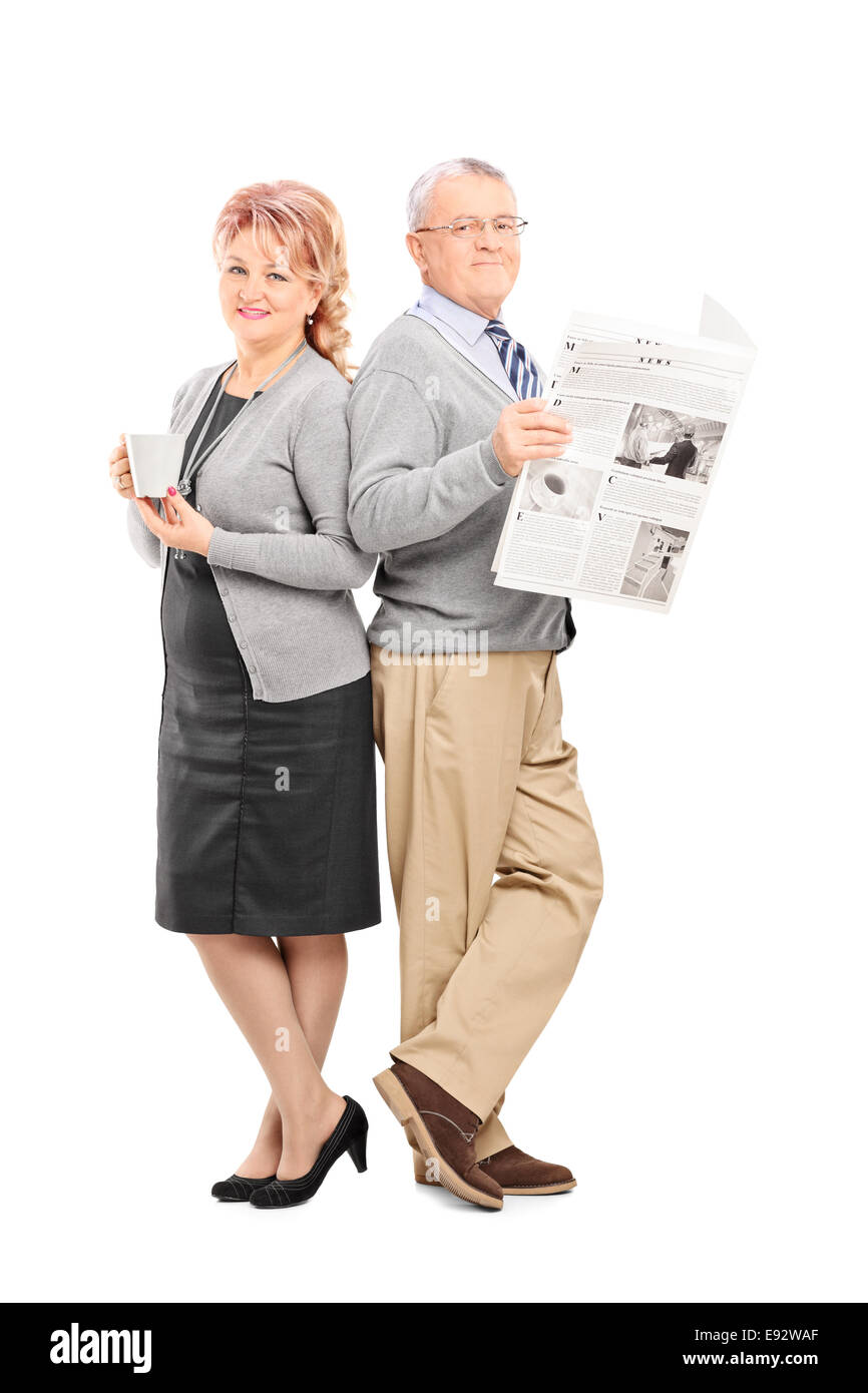 Full length portrait of a mature couple with a newspaper and cup of coffee isolated on white background Stock Photo