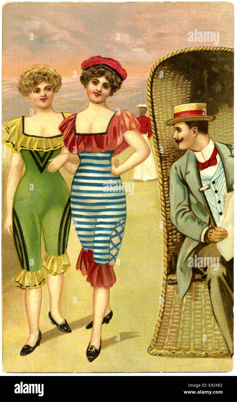 Man in Wicker Chair Staring at Two Fashionable Women in One-Piece Bathing Suits Strolling Along Beach, Postcard, circa early 1900's Stock Photo