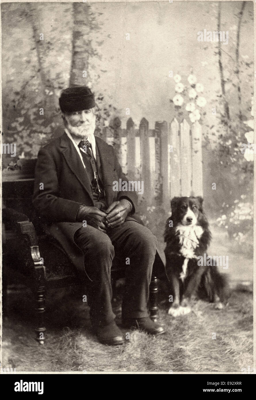 Seated Man on Bench with Dog, Studio Portrait, circa 1897 Stock Photo
