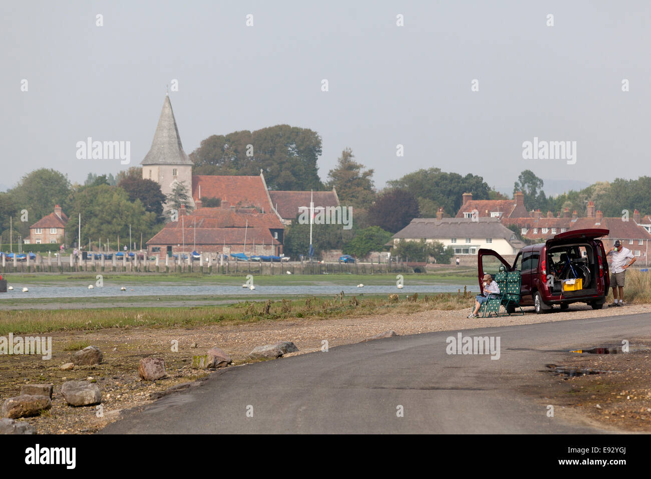 Couple picnicking by their car at the edge of Chichester Harbour