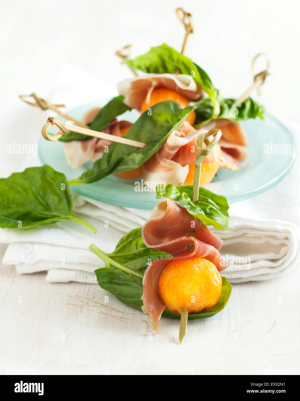 Appetizer with melon and prosciutto on skewers Stock Photo