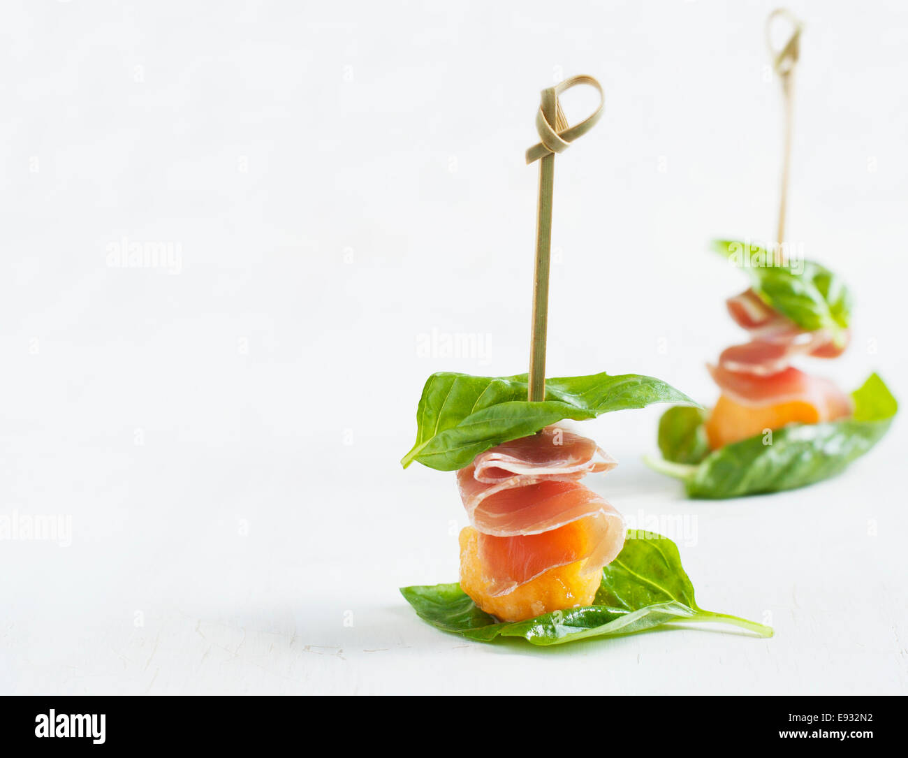 Appetizer with melon and prosciutto on skewers Stock Photo