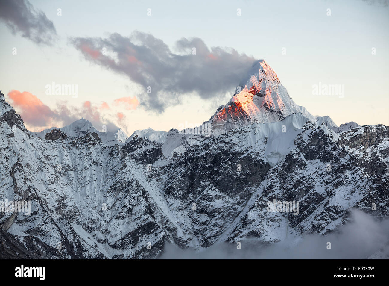 First rays of the rising sun on the top of sacred Ama Dablam peak (6814 m). Nepal, Himalayas. Stock Photo