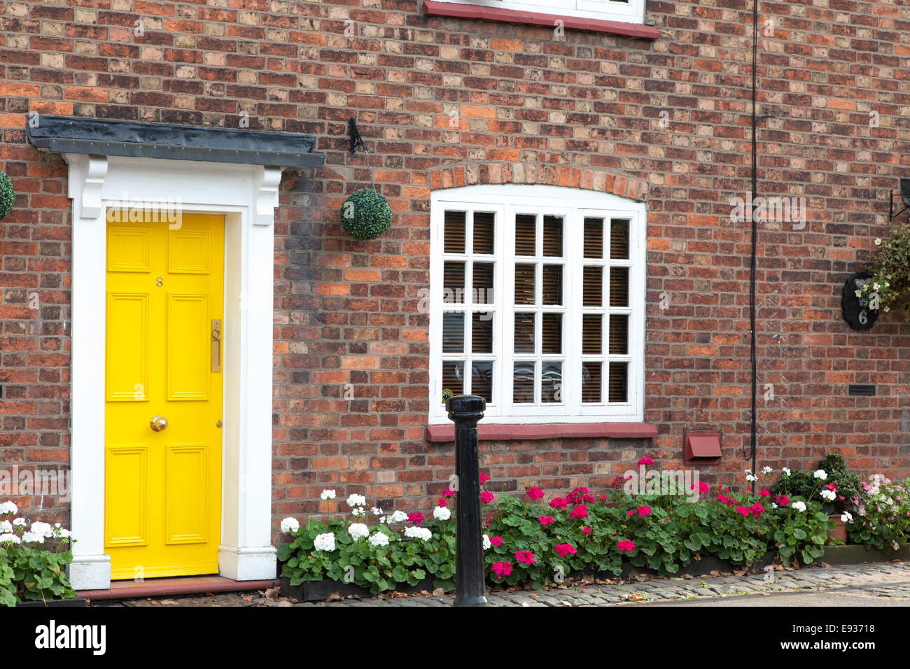 Brick cottage with yellow door, England, UK Stock Photo