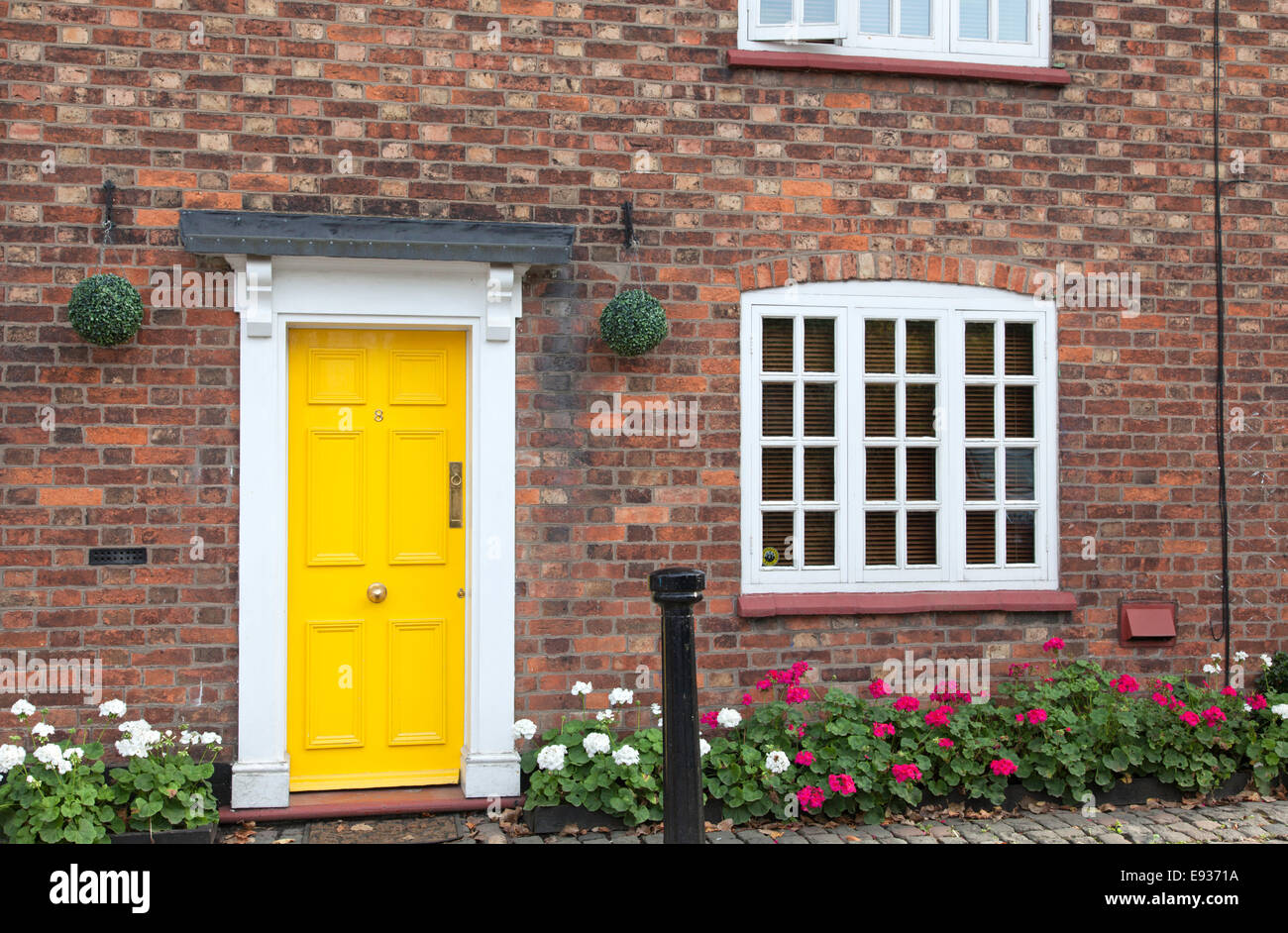 Brick cottage with yellow door, England, UK Stock Photo
