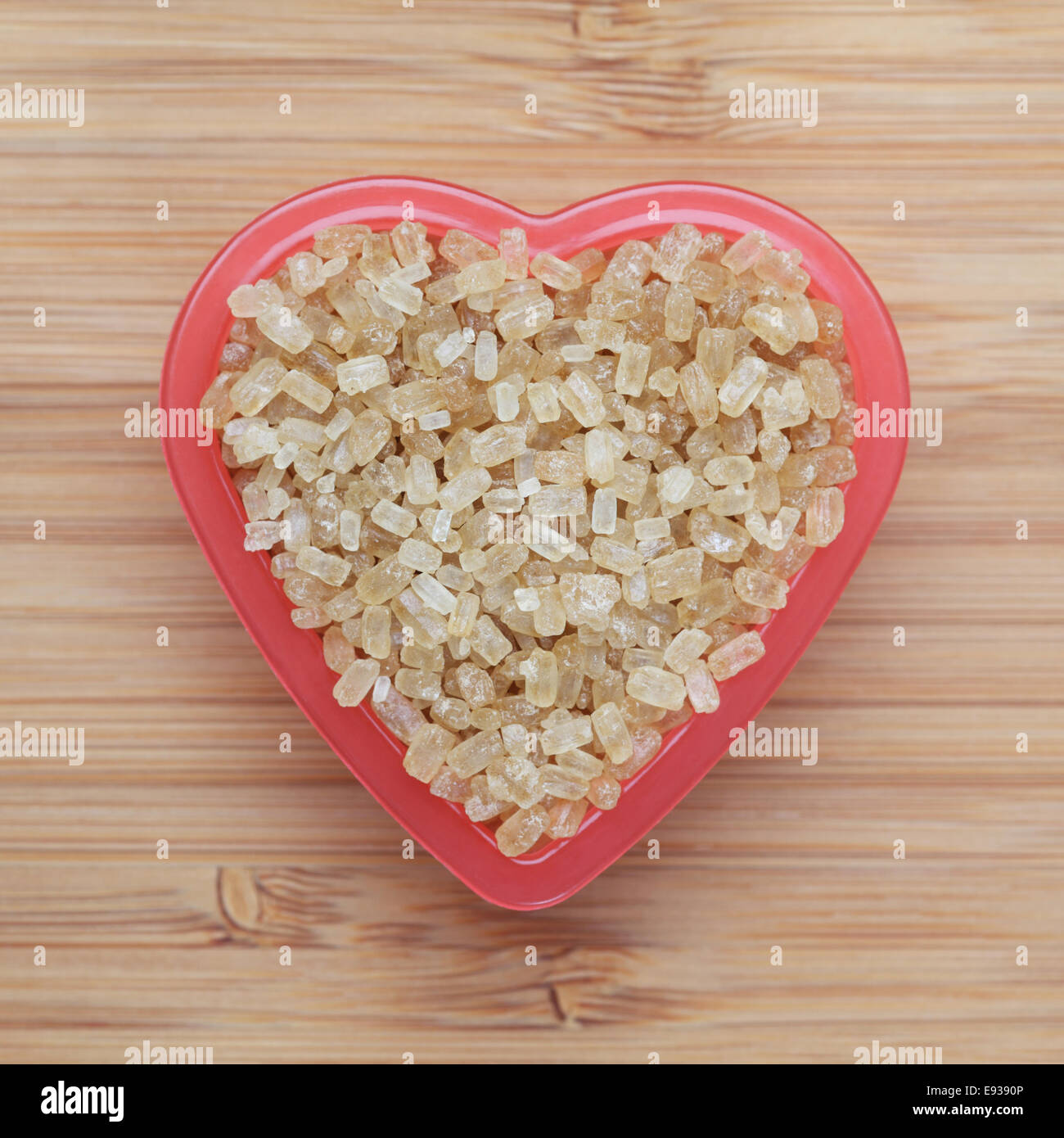 Brown cane sugars in a heart bowl. Closeup Stock Photo Alamy