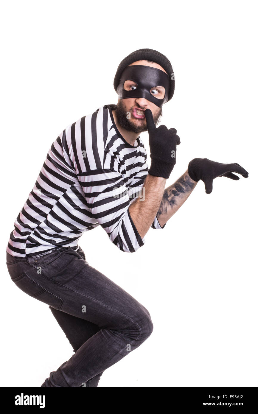 A thief with mask quietly sneaking. Portrait isolated on white background Stock Photo
