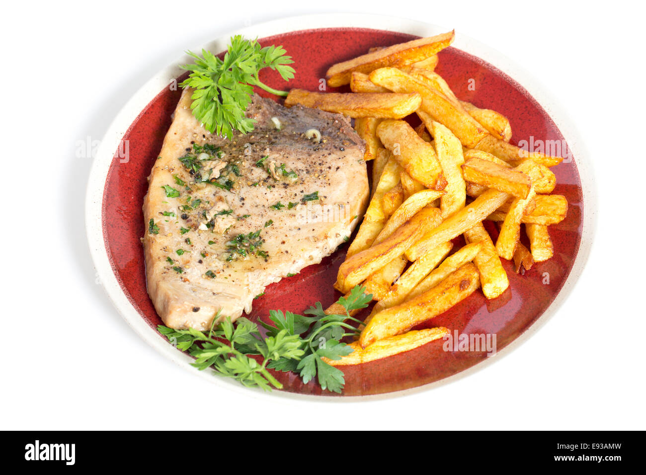 Swordfish steak cooked on a plate with french fries and a parsley and garlic butter sauce Stock Photo
