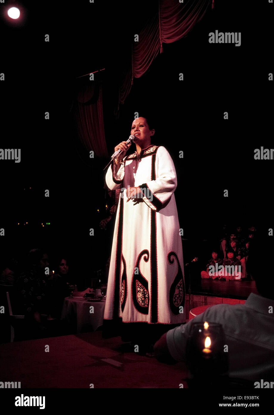 Famed Hawaiian singer Marlene Sai performs her classic island-style songs at a hotel dinner show celebrating Christmas in Honolulu in 1980. Consider a living legend of Hawaiian music, she became a recording star as a teenager and has kept up a solo singing career that included an appearance in New York City's Carnegie Hall in 2008. Her first album 'Kainoa' in 1959 is still considered one of Hawaii's all-time great musical albums. Stock Photo