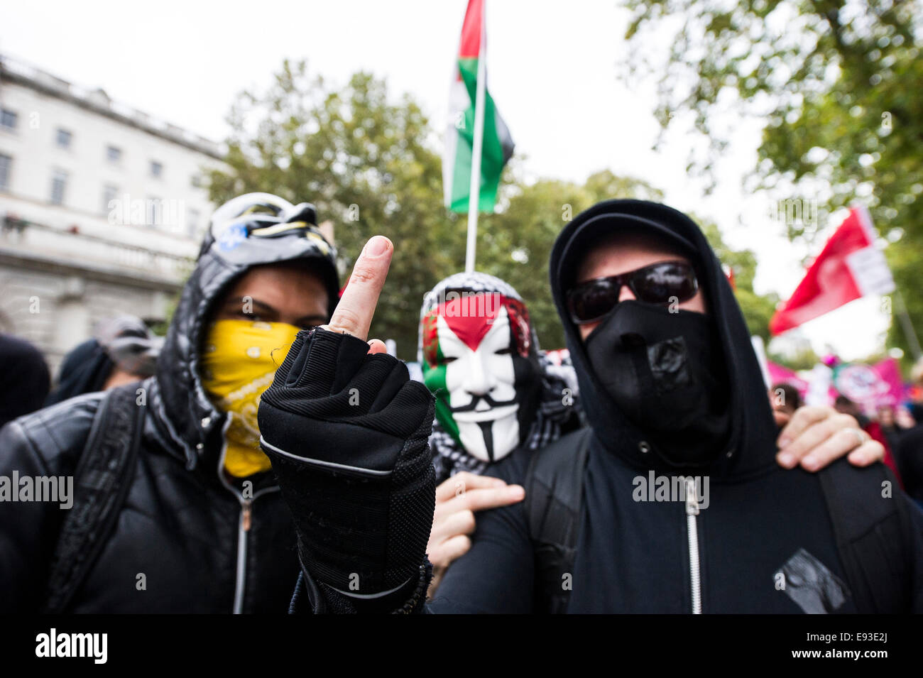 London, UK. 18 October 2014. 'Britain Needs A Payrise'   A TUC national demonstration in Central London.  A gesture made by a member of Black Bloc as the march prepares to set off from the Embankment. Photo: Gordon Scammell/Alamy Live News Stock Photo