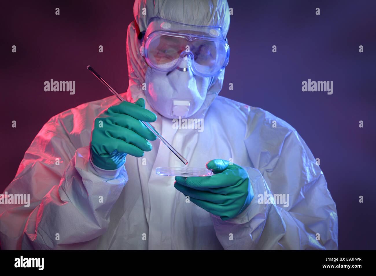 Scientist in Hazmat suit and protective gear working with virus on Petri dish Stock Photo