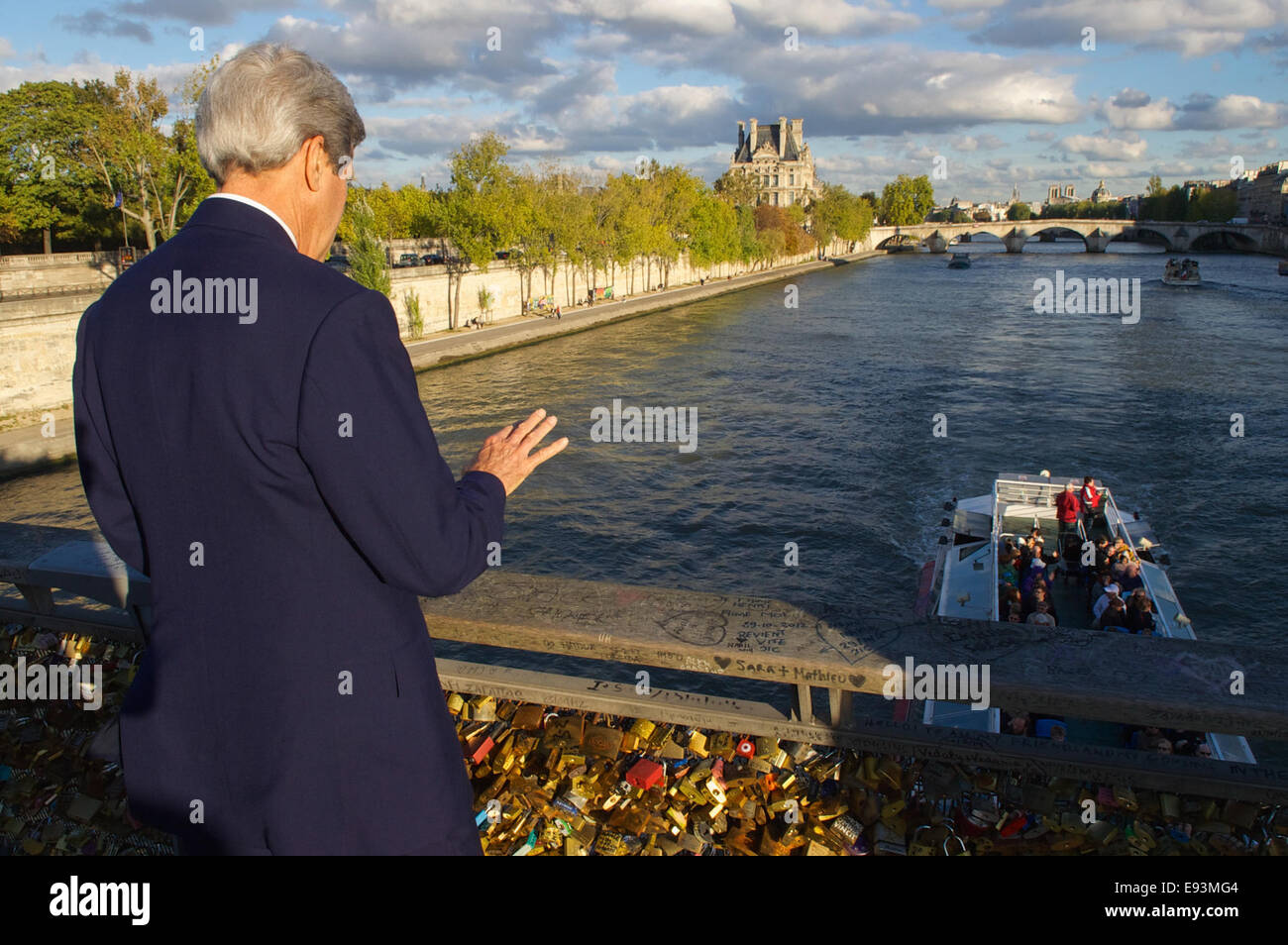 U.S. Secretary of State John Kerry waves to boaters going under the Passerelle del Solferino as he crosses the Seine River while walking to the Quai d’Orsay in Paris, France, for a meeting with French Foreign Minister Laurent Fabius on Oct. 13, 2014. Stock Photo
