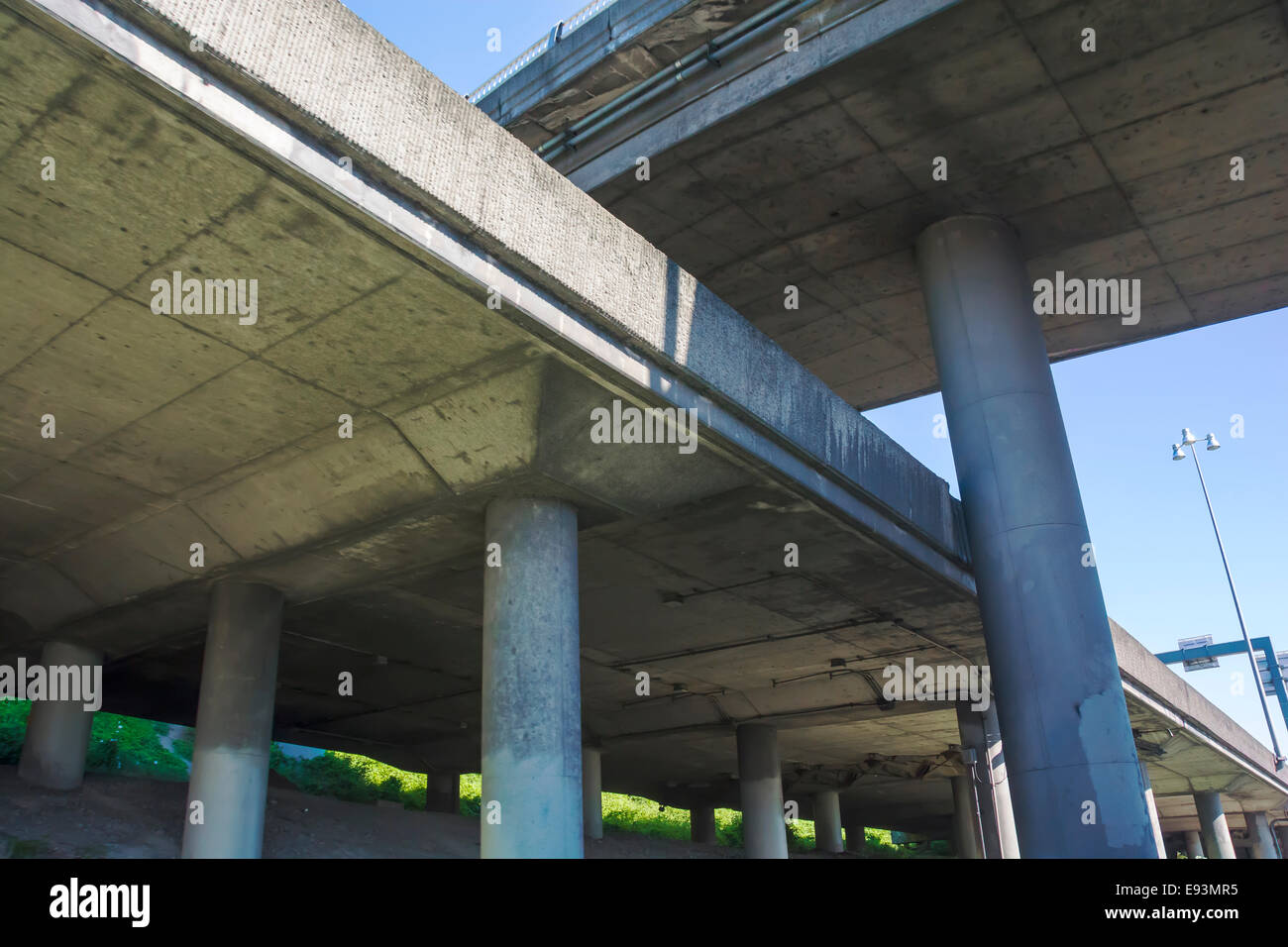 Elevated freeway concrete bridges criss-cross as seen from below. Stock Photo