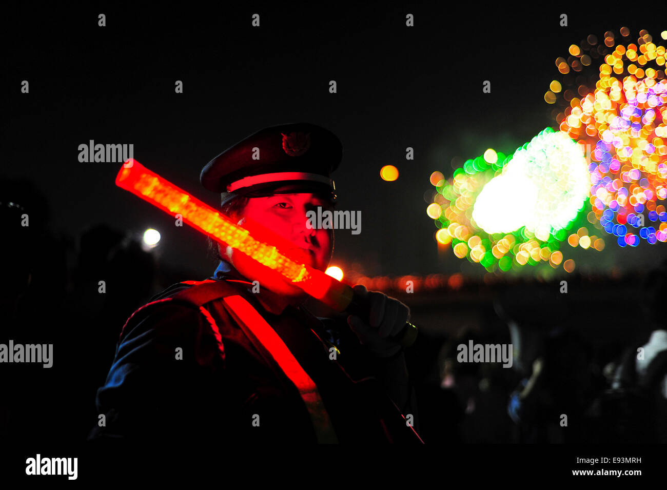 A security officer waves an illuminated baton to direct spectators at the Adachi Fireworks Festival. Stock Photo