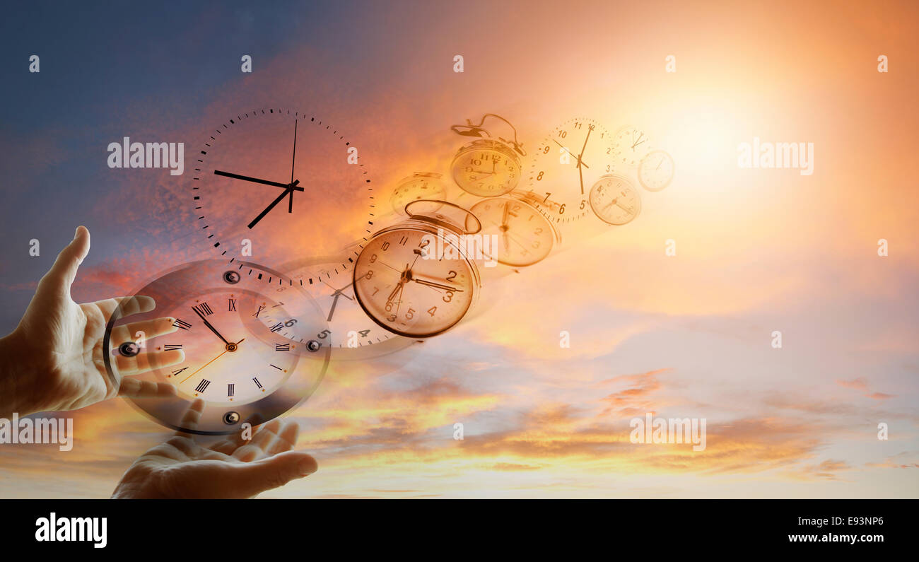 Hands and clocks in sky Stock Photo