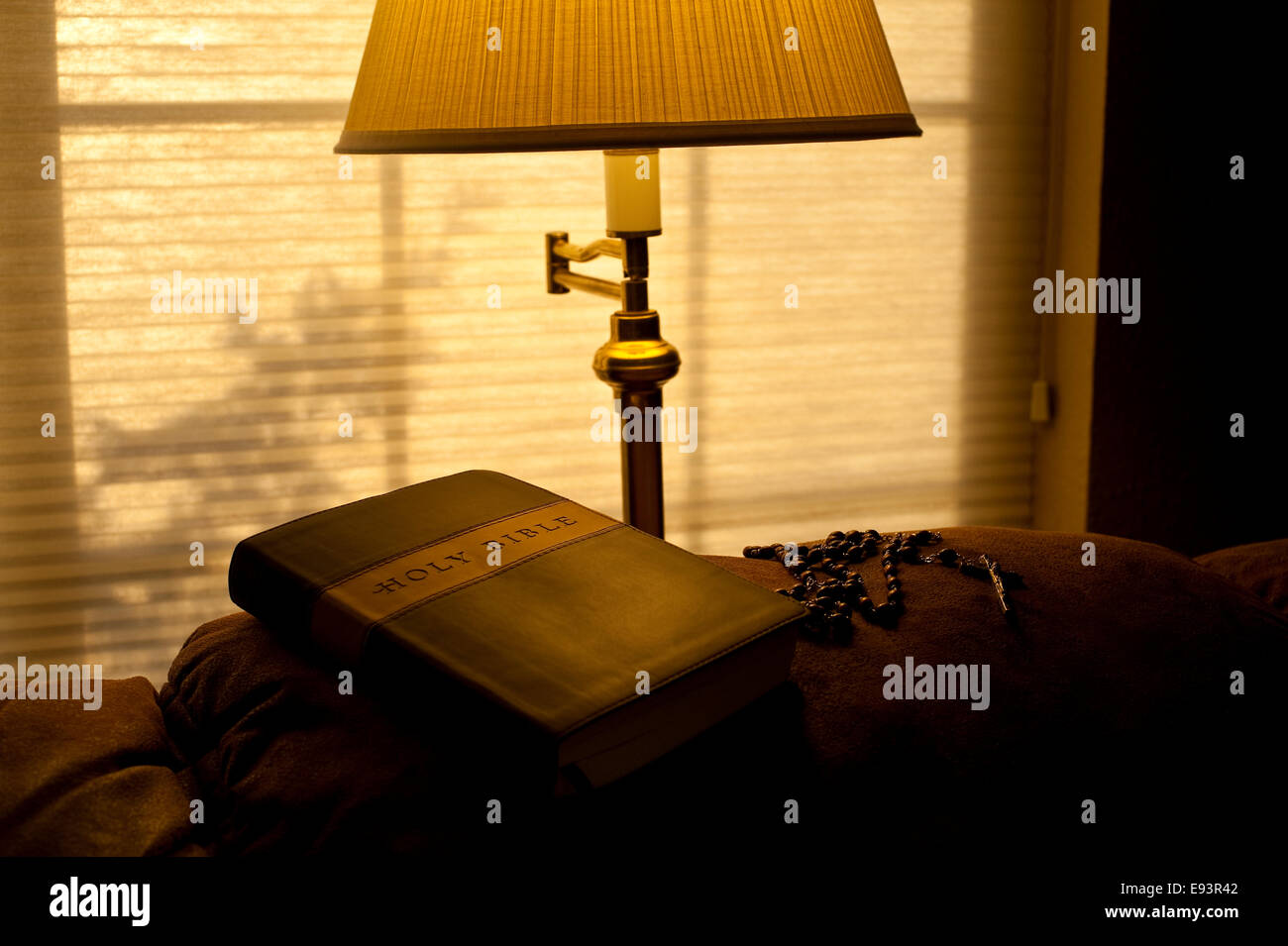 Bible on back of couch with sunlight and warm light from lamp with