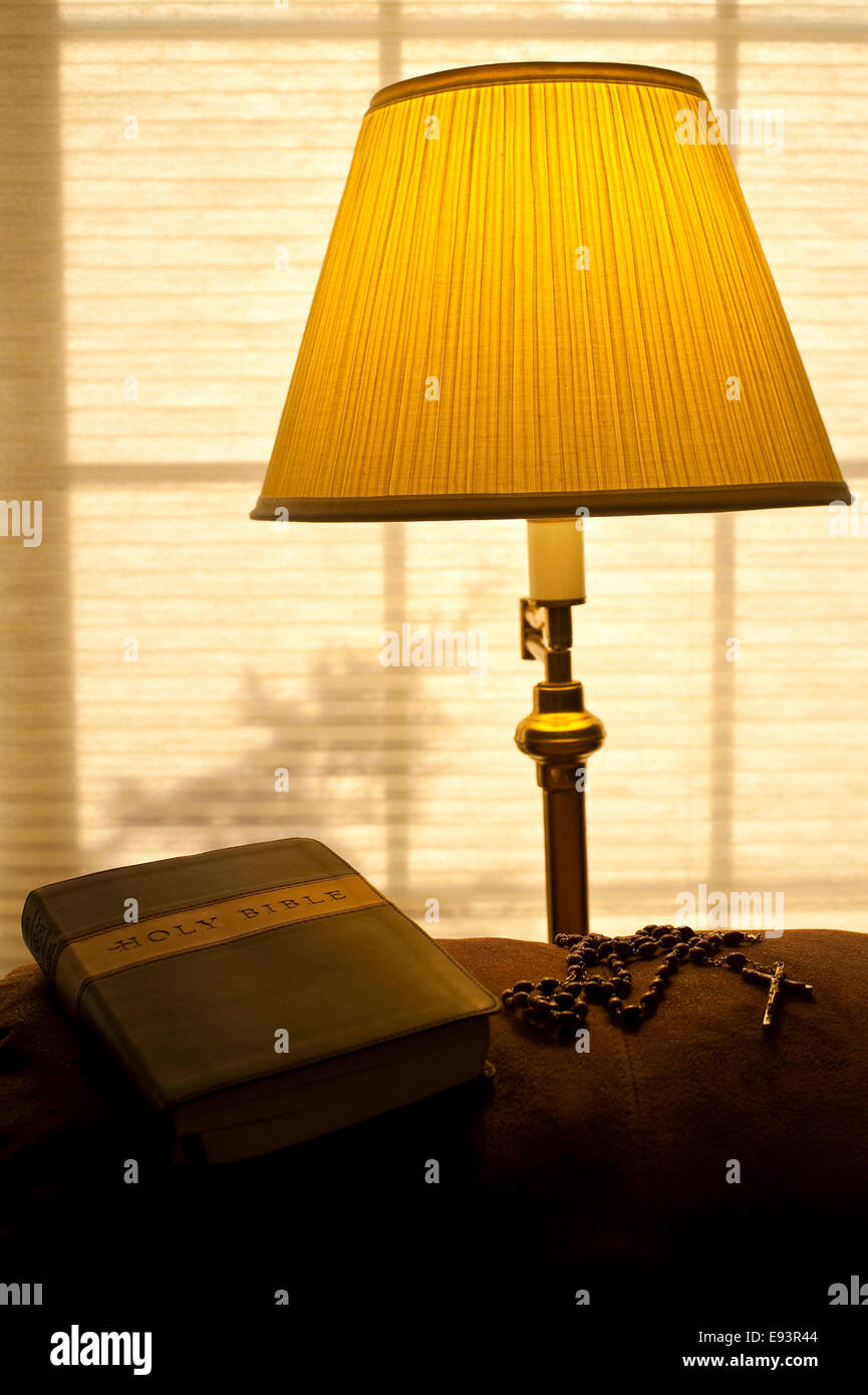 Bible on back of couch with sunlight and warm light from lamp with