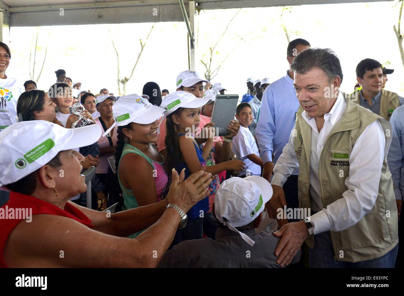 Jamundi, Colombia. 18th Oct, 2014. Image provided by Colombia's Presidency, shows Colombian President, Juan Manuel Santos (R), taking part during an act of delivery of lands to farmers victims of land grab, in Jamundi, Cauca Valley, Colombia, on Oct. 18, 2014. Credit:  Juan Pablo Bello/Colombia's Presidency/Xinhua/Alamy Live News Stock Photo