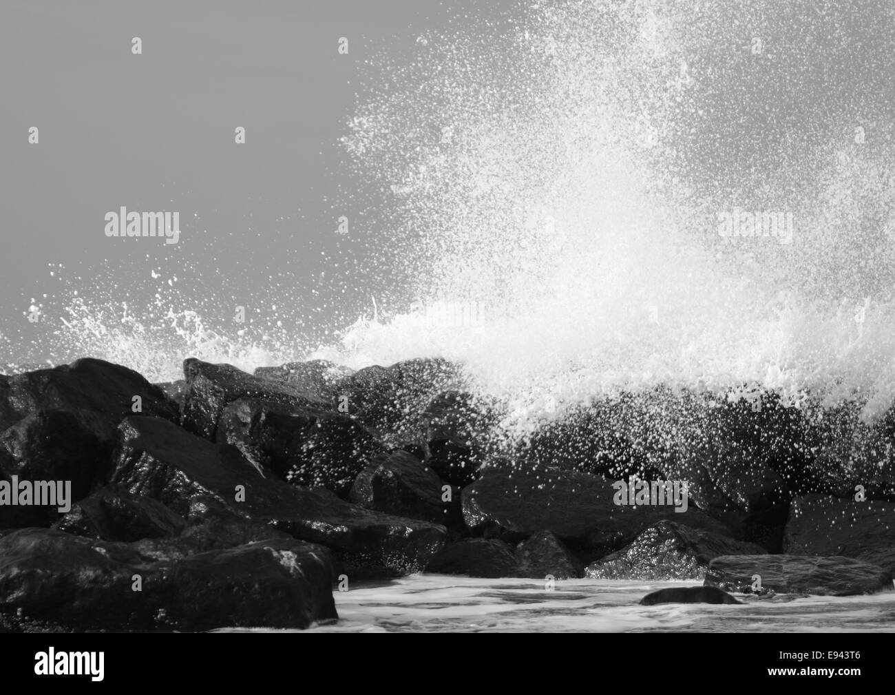 Crashing waves against black rocks at coast Stock Photo