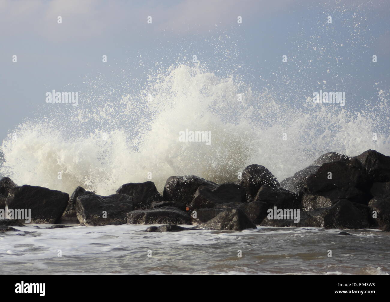 Crashing waves against black rocks at coast Stock Photo