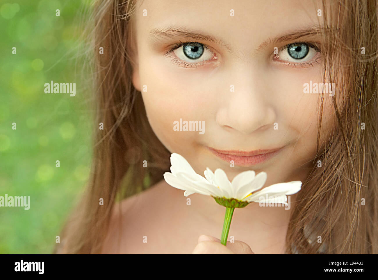 Little Girl With Chamomile Looking At The Camera. Close-Up Stock Photo ...