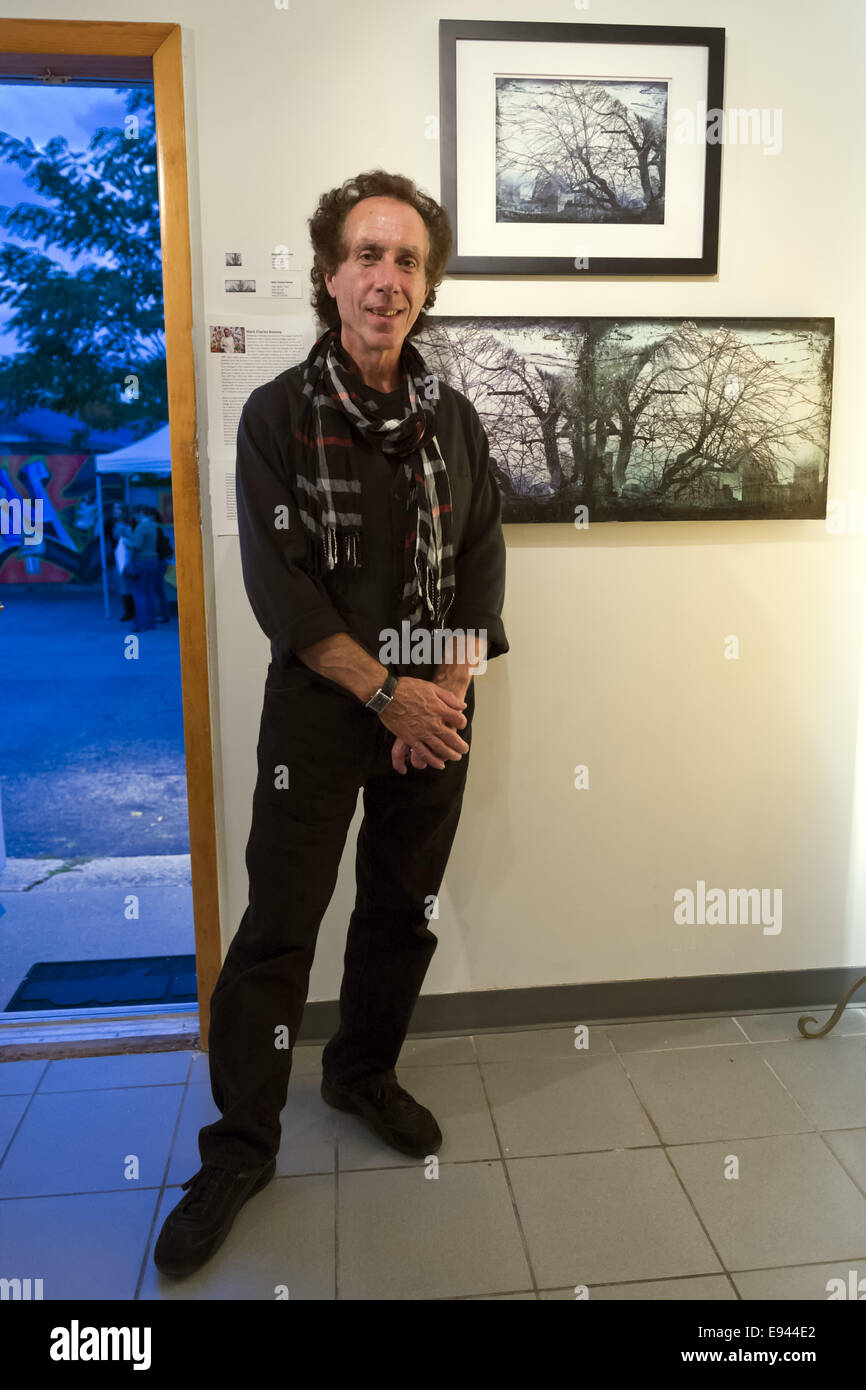 Massapequa, New York, USA. 18th Oct, 2014. Artist MARK CHARLES ROONEY, of Hazleton, PA, stands next to his photographs Winter Trees, during Studio 5404 Art Space opening reception for art show Taking it to the Street. The show featured new works by emerging and up-and-coming local and New York artists. Studio 5404 is on the South Shore of Long Island. Credit:  Ann Parry/ZUMA Wire/Alamy Live News Stock Photo