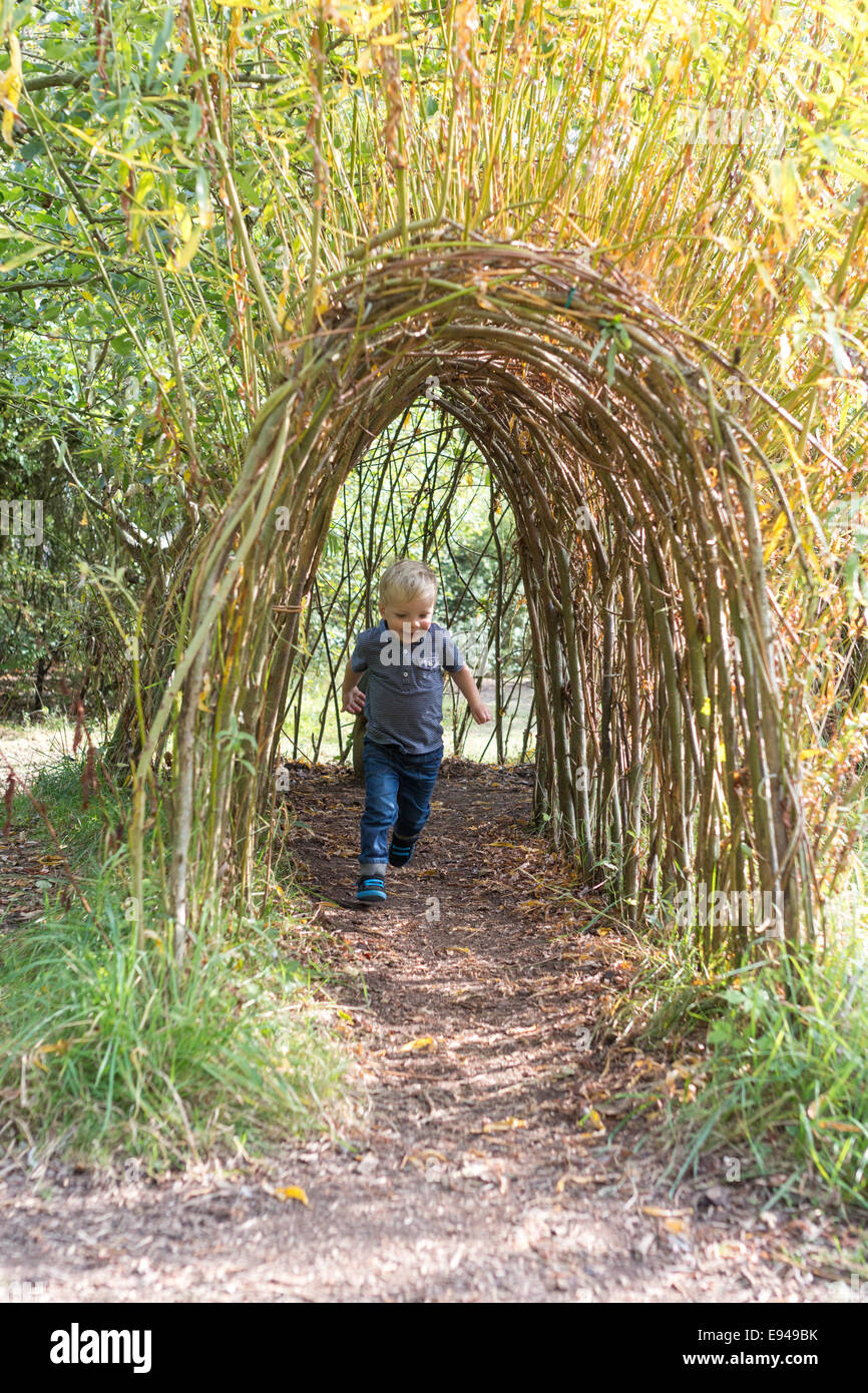 boy running through willow tunnel Stock Photo