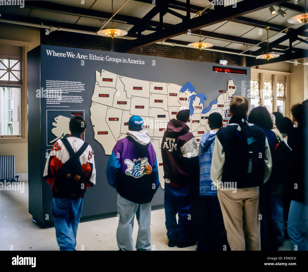 Students looking at U.S. Ethnic groups map Ellis Island Museum New York NY USA Stock Photo