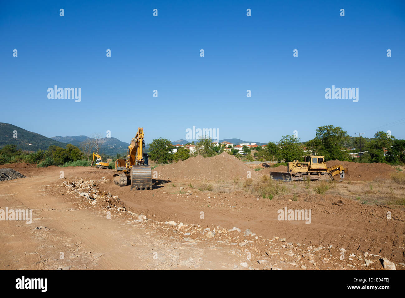 Big excavators on new construction site against a blue sky Stock Photo