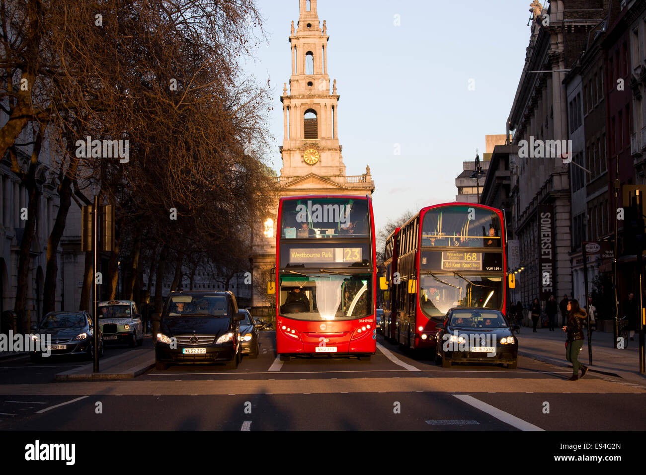 Buses waiting at lights central London low sun Stock Photo