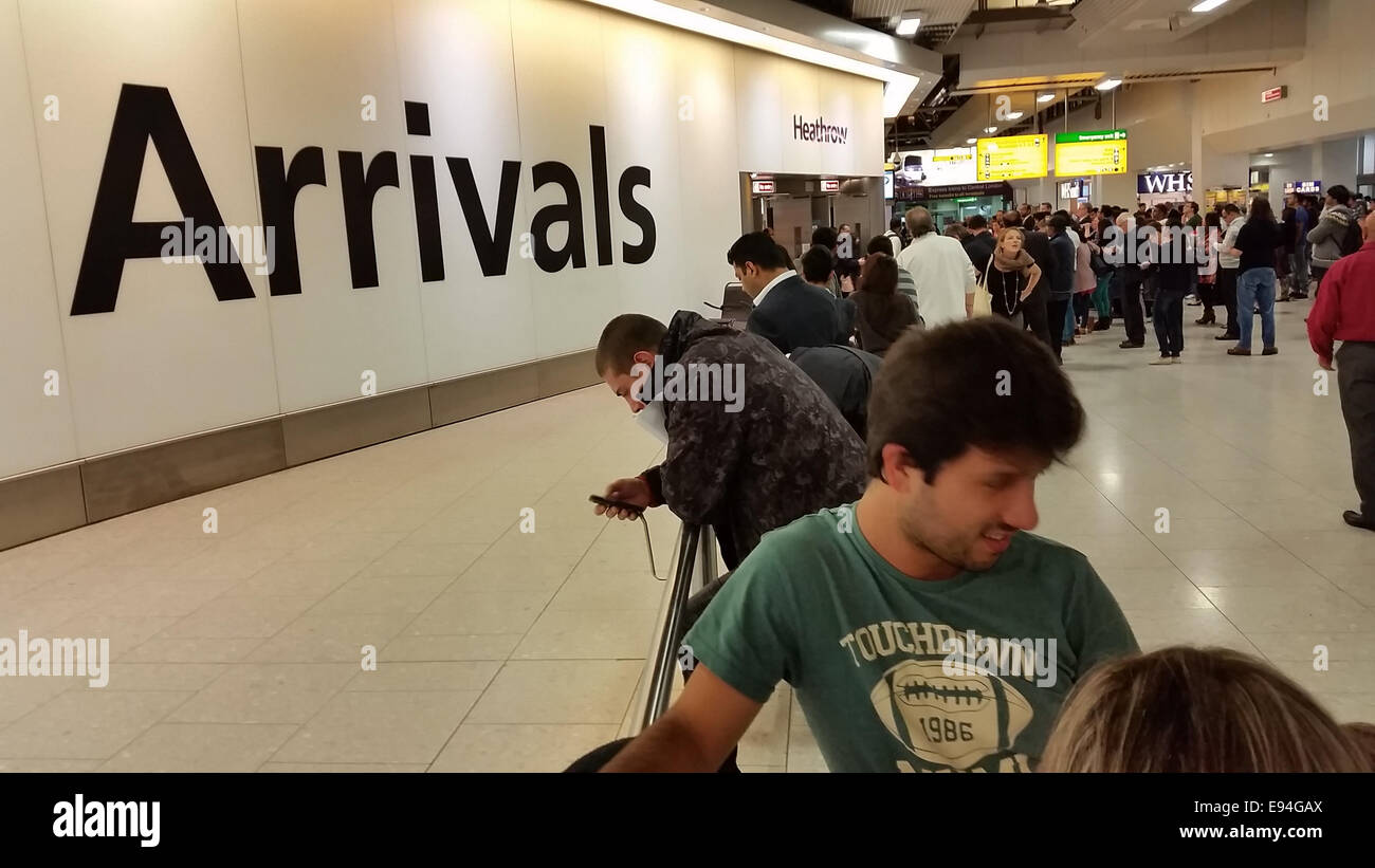 London, UK - 19 October 2014. People are seen at the Heathrow Terminal 4 arrivals gate. Screening at Heathrow Terminal 1 will begin on 14 October, before being extended to other terminals at the airport as well as Gatwick and Eurostar. The Department of Health estimates that 85% of all arrivals to the UK from affected countries will come through Heathrow. Photo: David Mbiyu/ Alamy Live News Stock Photo