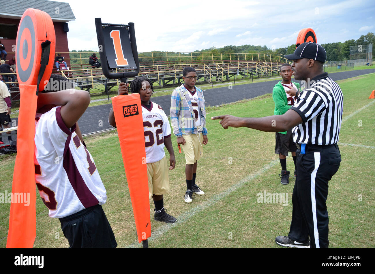 Referee explains to  people how to move the down markers just before a high school football game Stock Photo
