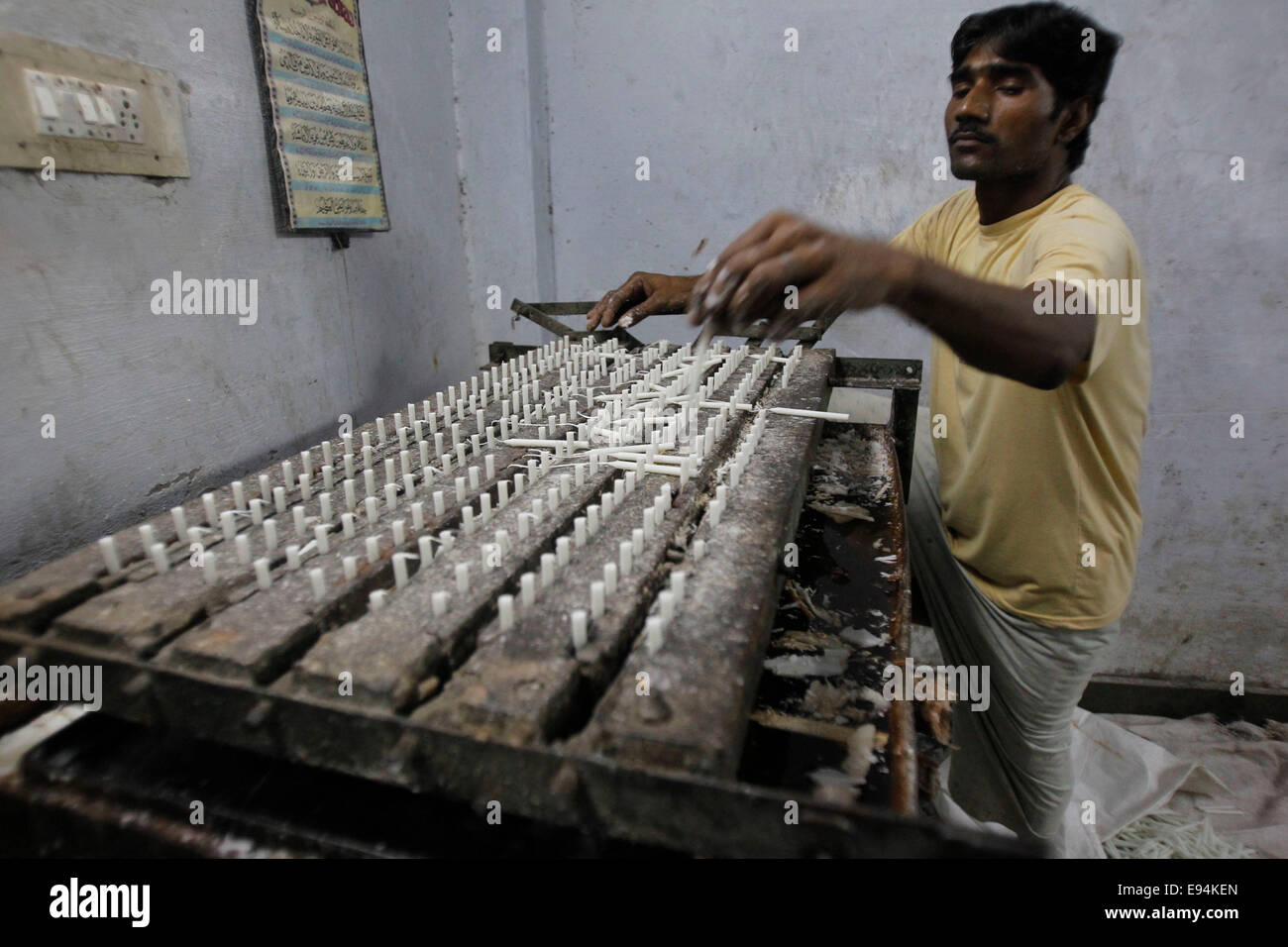 A worker makes candles ahead of Diwali festival in side a home in