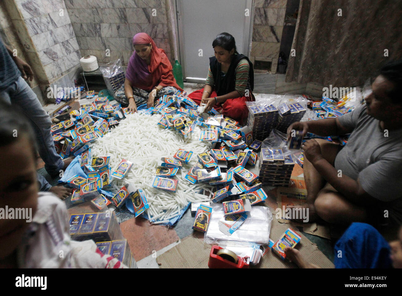 Women pack the produced candles ahead of Diwali festival in a candle