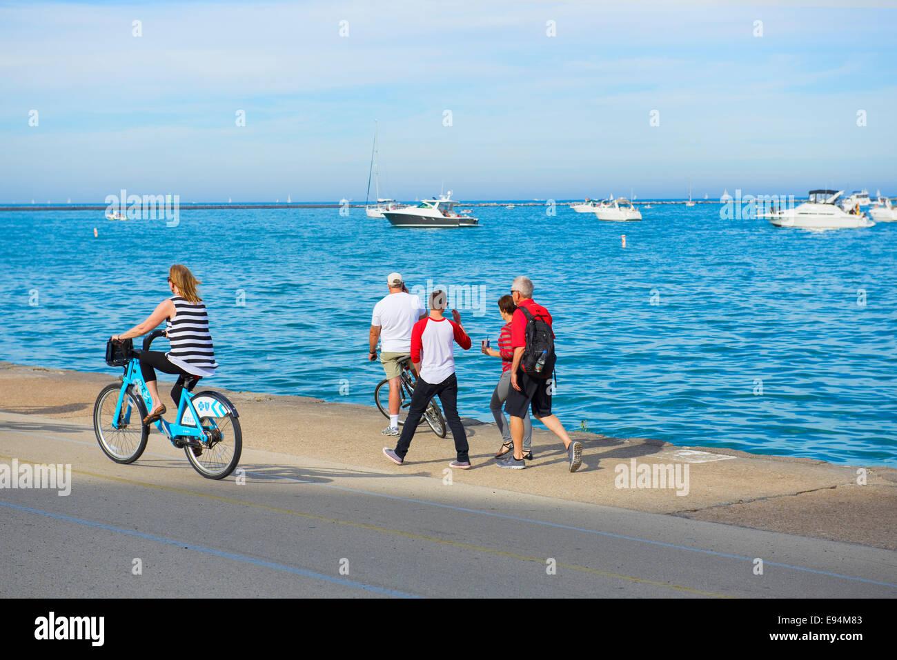 Bicycling along the Lakeshore, People Walking Strolling and Cycling Lake Shore Stock Photo