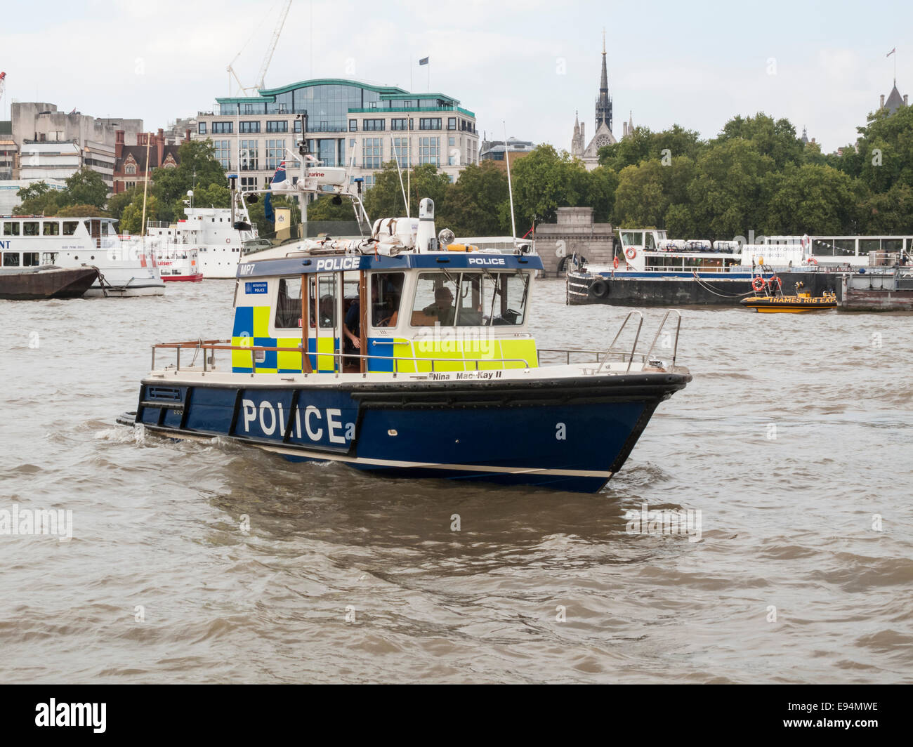 Riverside view of a small Thames River Police boat underway, sailing on patrol on the River Thames, London, UK near Victoria Embankment Stock Photo