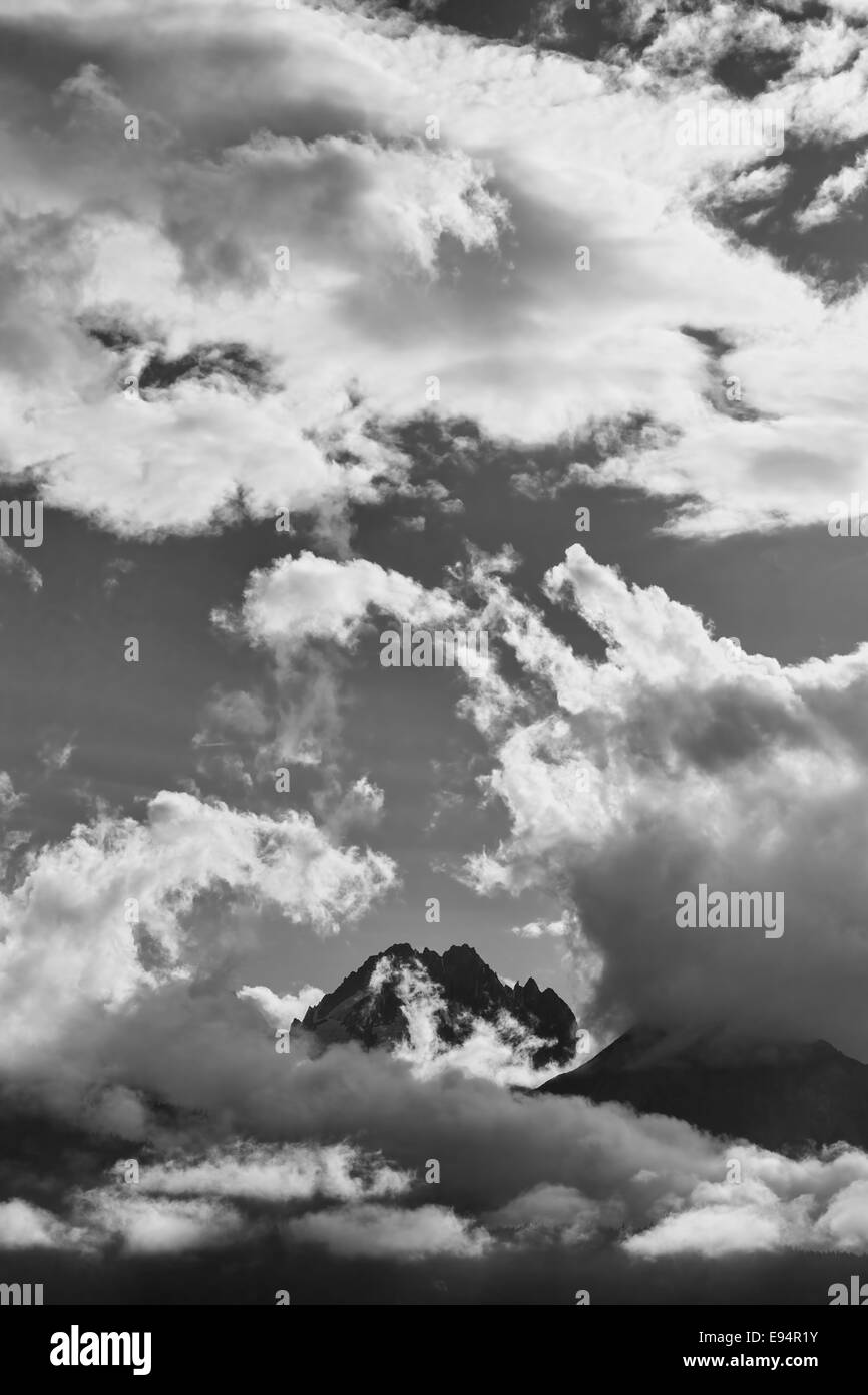 Dramatic clouds and light on tall mountain peaks in black and white ...