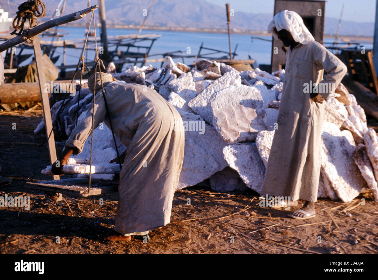 Arab merchants weighing blocks of sea salt in Ras al Khaimah, 1975 Stock Photo