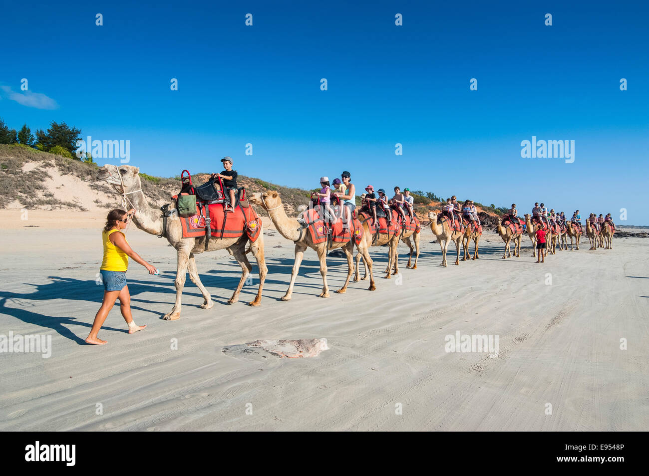 Tourists riding on camels on Cable Beach, Broome, Western Australia Stock Photo