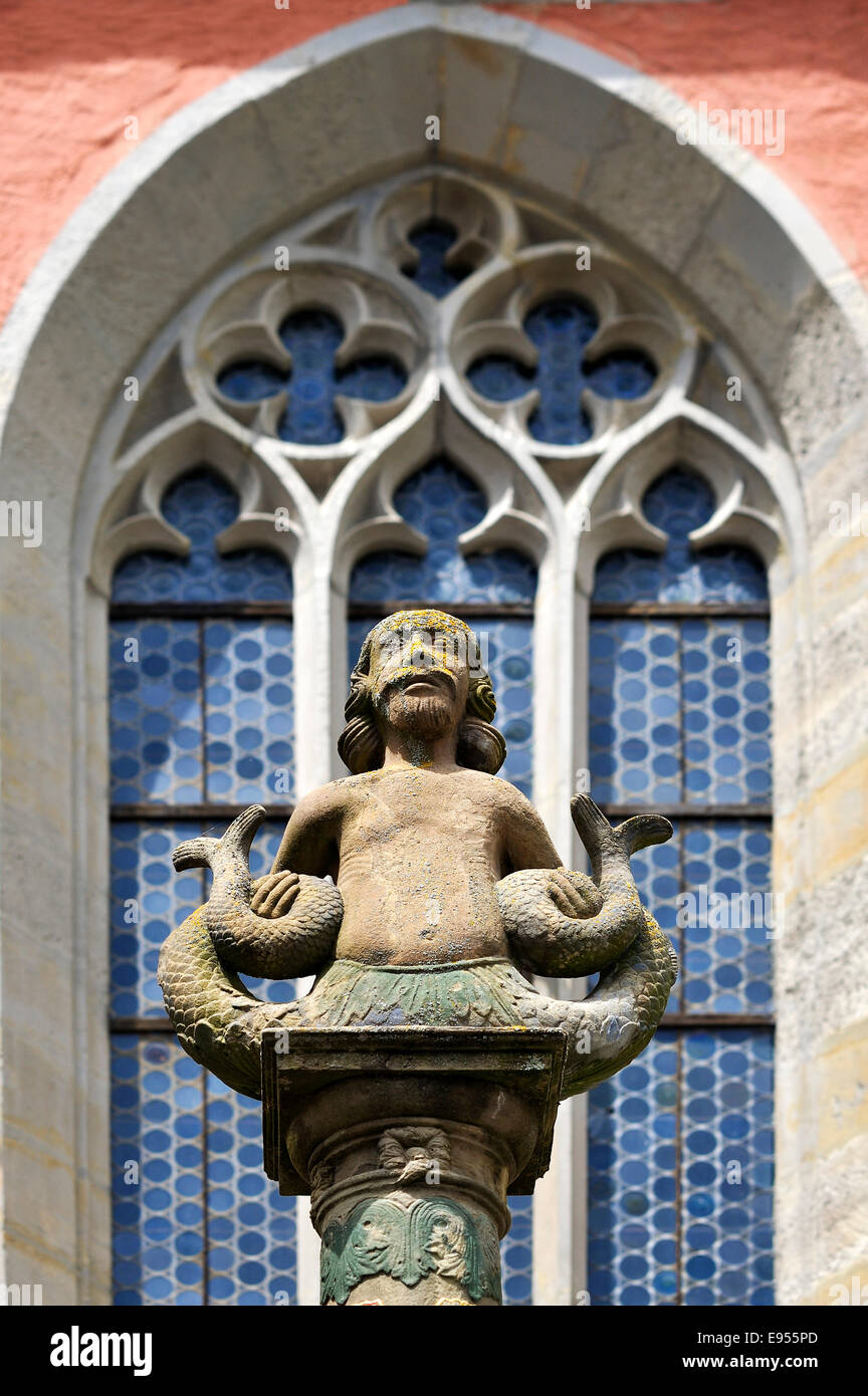 Merman, sculpture on the Johannisbrunnen fountain, gothic tracery window of the St. John church behind, 14 Century Stock Photo