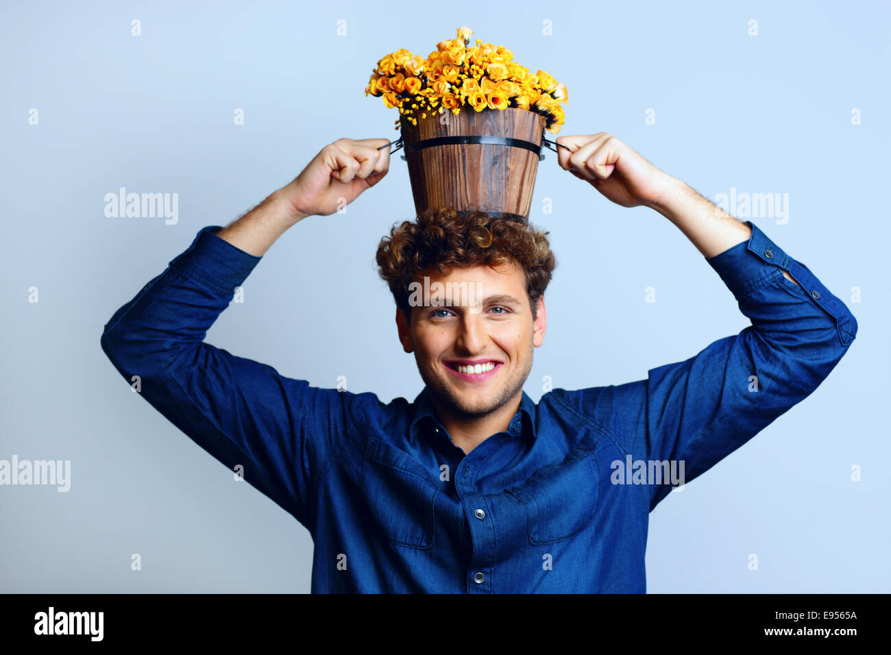 Smiling man with a bucket on his head with flowers Stock Photo Alamy