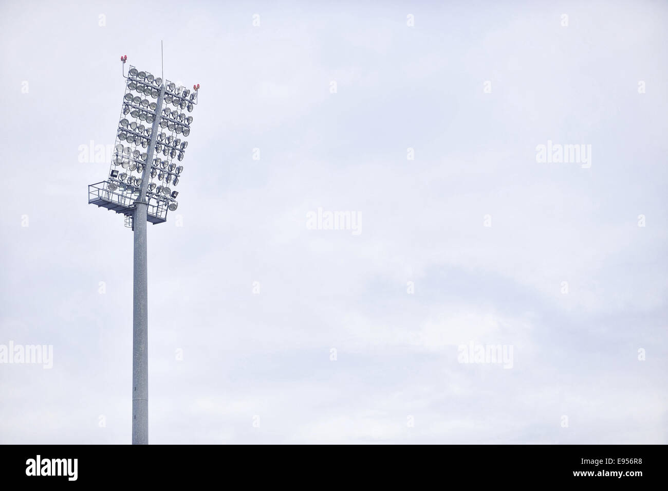 Sports arena floodlights isolated with overcast sky on background Stock Photo